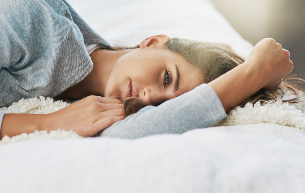Shot of a young woman lying on her bed