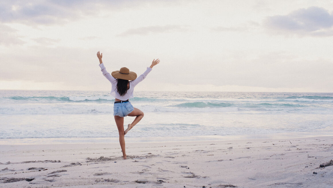 Hipster Girl Practicing Yoga Pose on Beach