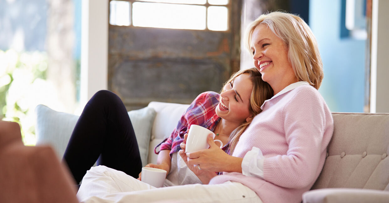 Mature Mother With Adult Daughter Watching TV At Home