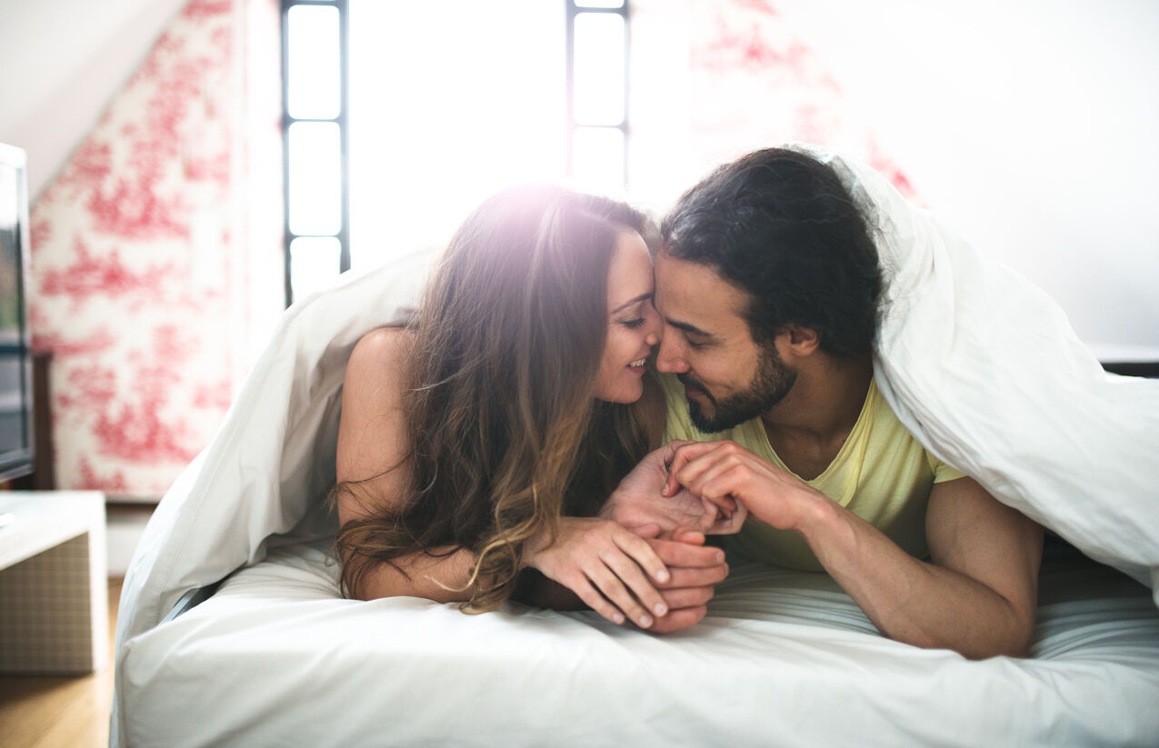 couple kissing on the bed on early morning