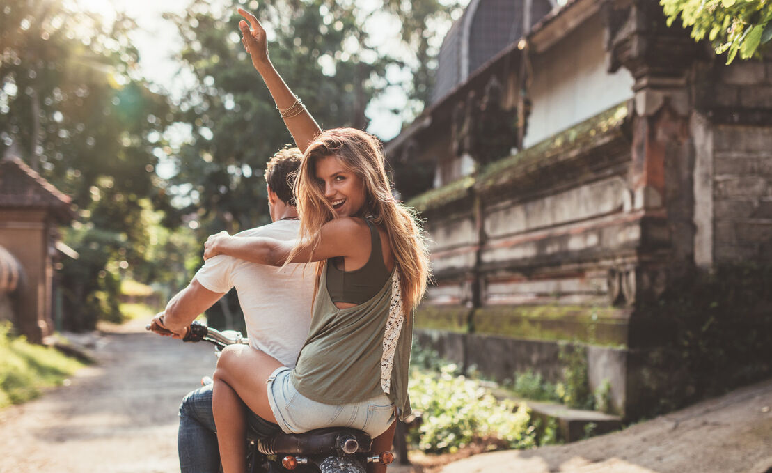 Couple enjoying motorcycle ride on village road