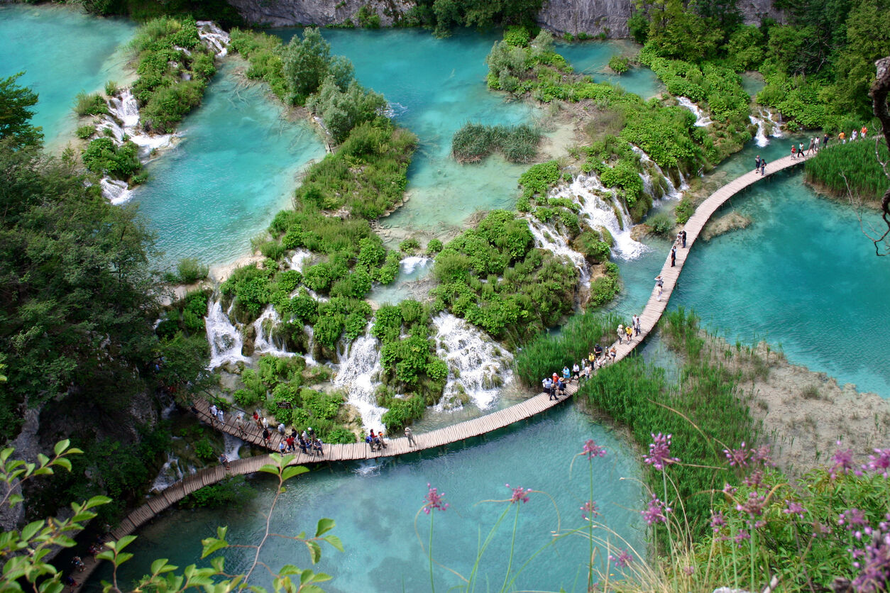 "People walking on a curvilinear footbridge over bright green water, Plitvice Lakes National Park (Croatia).View my Lightbox"