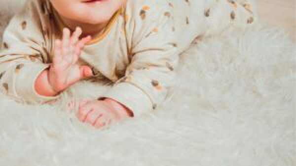 Baby ligt op een kleedje.