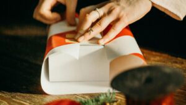 Een jonge vrouw pakt een cadeautje in.