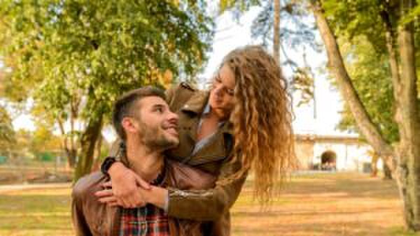 Een koppel lacht lief naar elkaar.