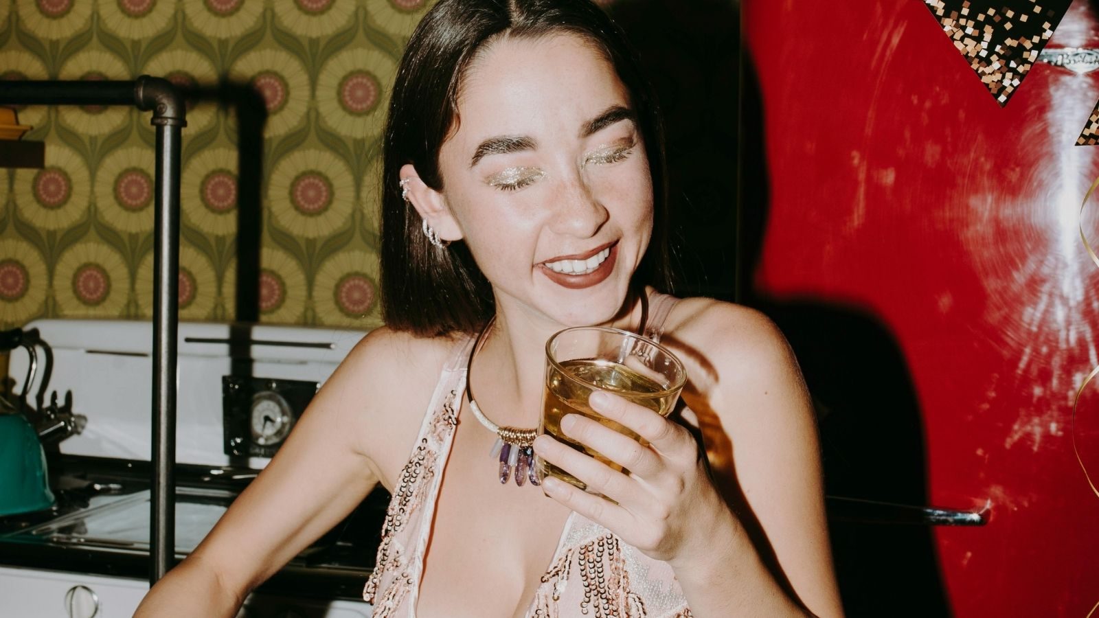Een vrouw lacht tijdens een kerstborrel.