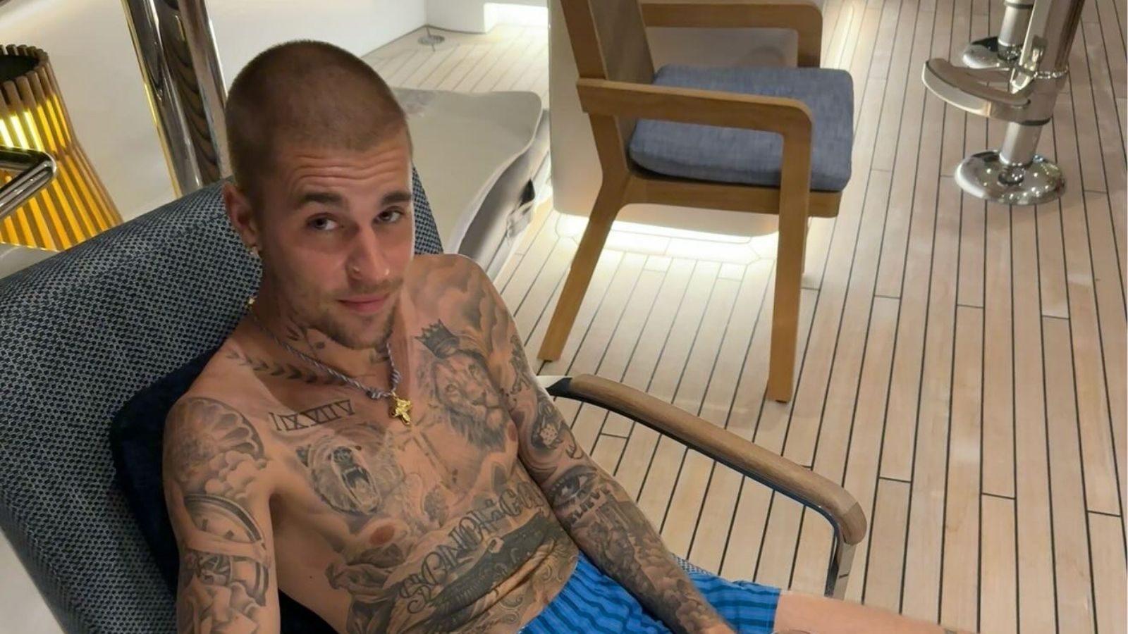 Justin Bieber op een stoel kijkend naar de camera.