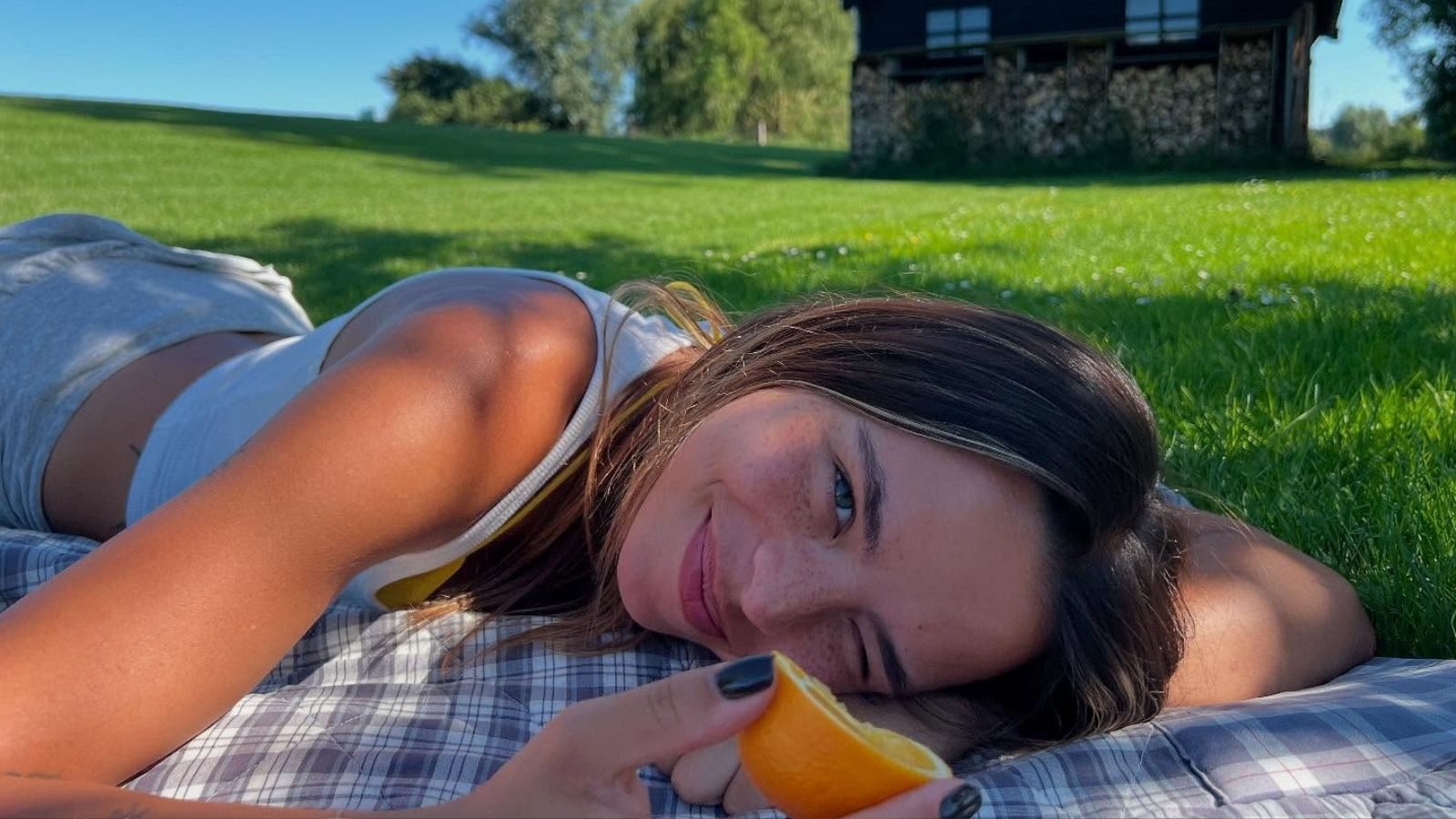 Vrouw ligt in een grasveld.