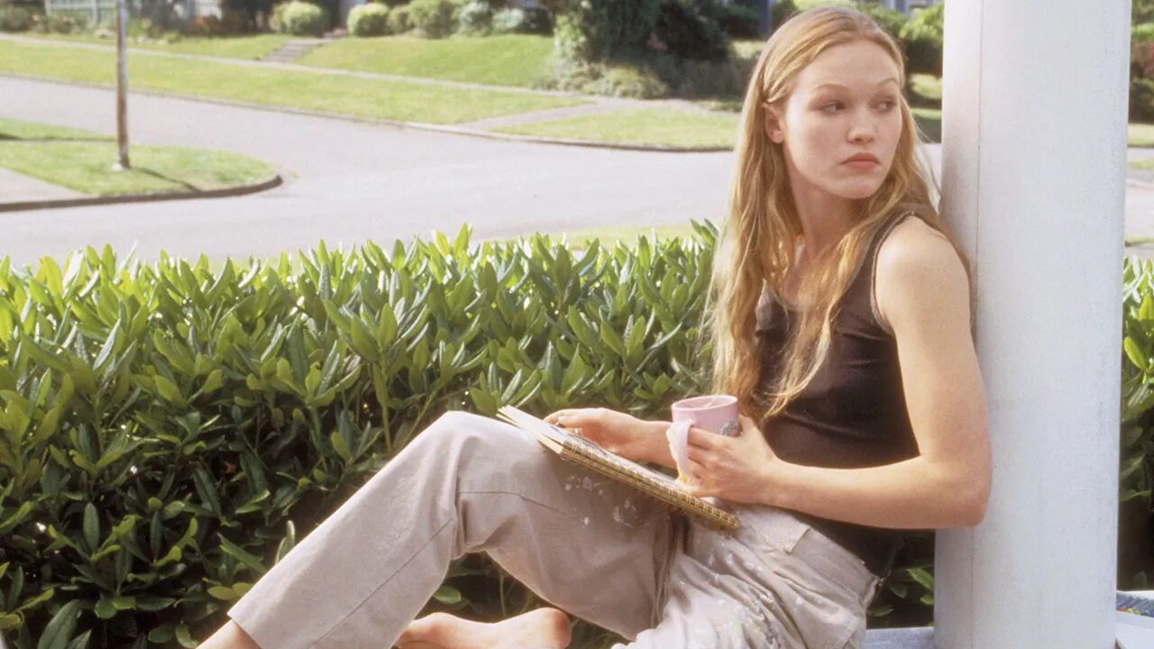 Kat met een boek in de tuin.