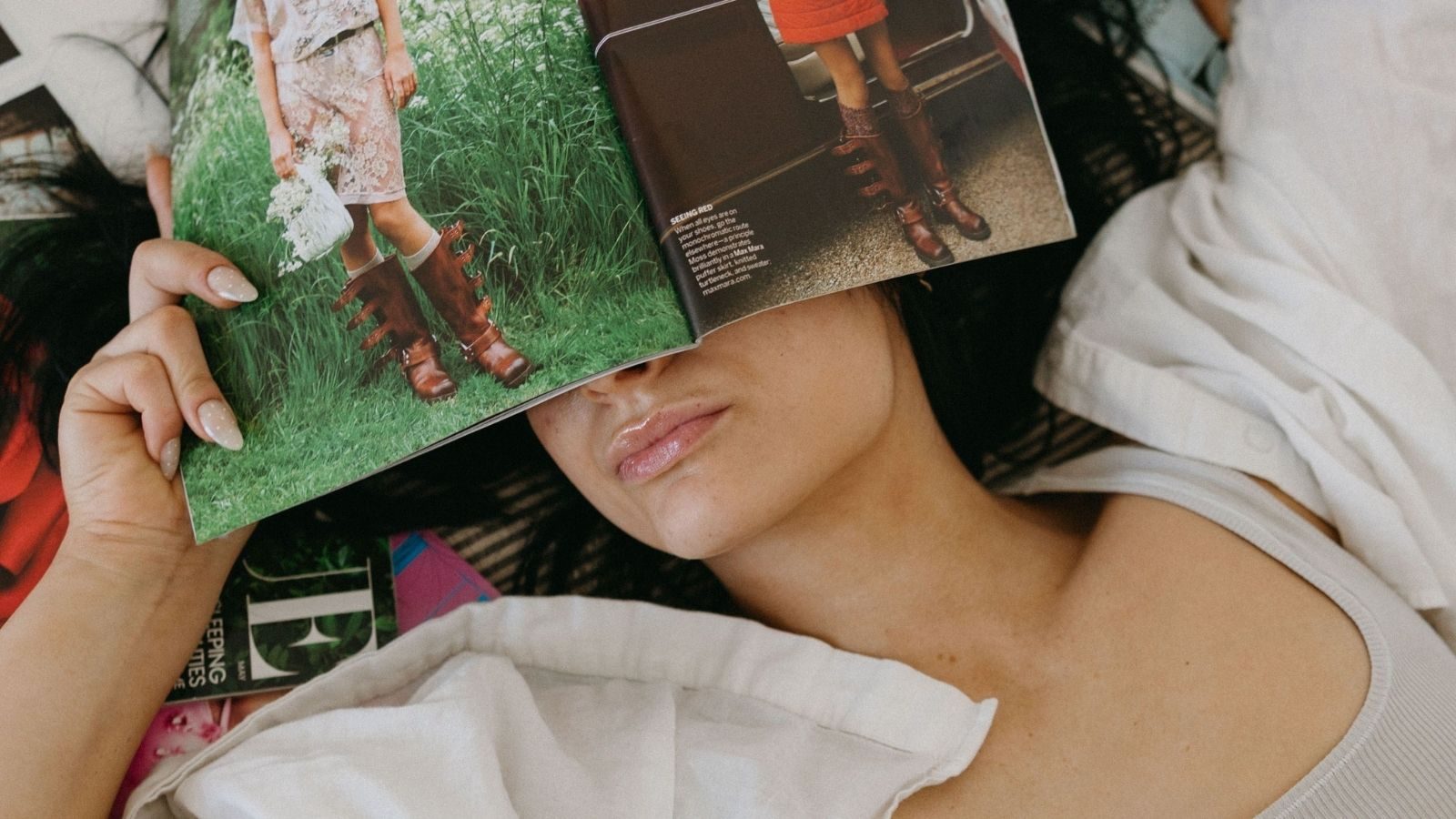 Vrouw met magazines om haar heen.
