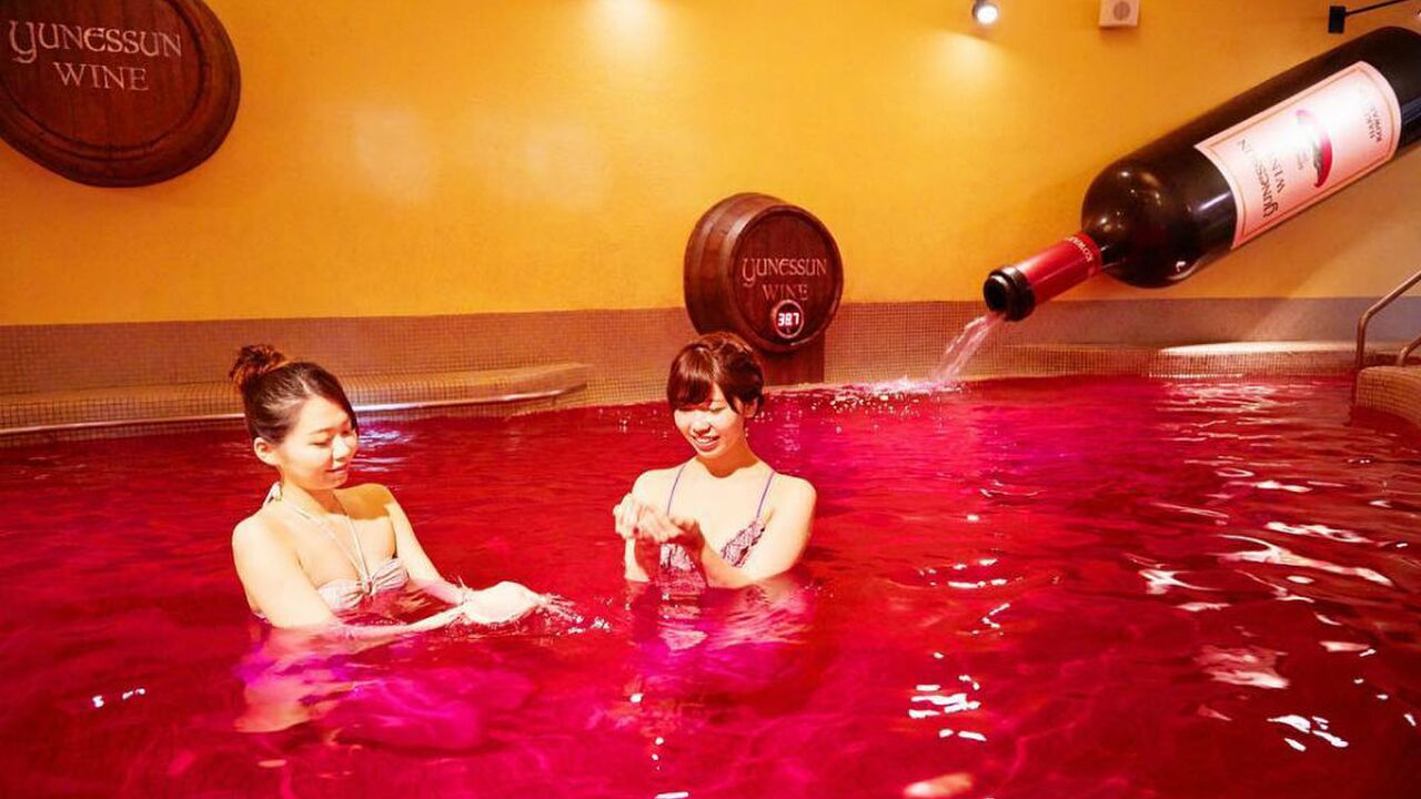 Illustratie voor: In deze spa in Japan kun je zwemmen in een bad gevuld met rode wijn