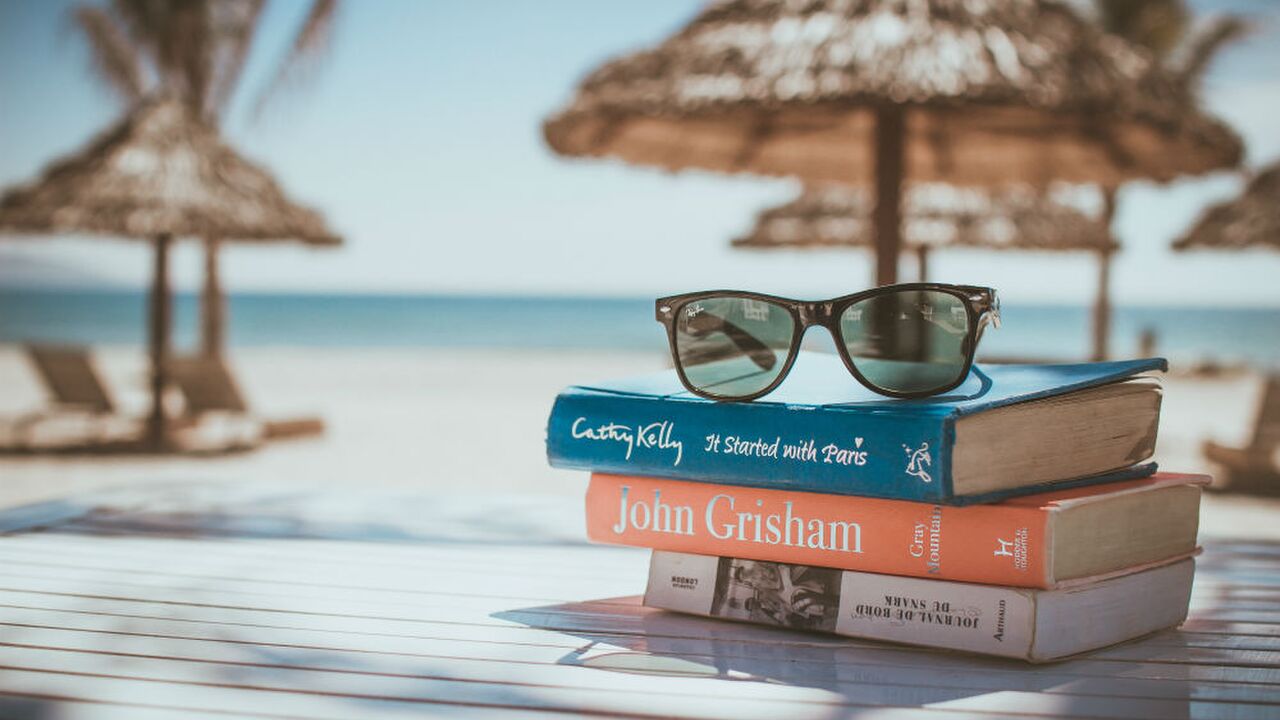 Illustratie voor: Deze boeken mogen absoluut niet ontbreken in je koffer als je op vakantie gaat