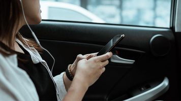 Vrouw op telefoon in auto.