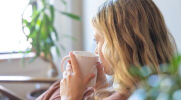 Vrouw met kopje thee op de bank.