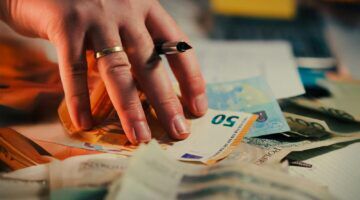Iemand maakt een berekening met geld.