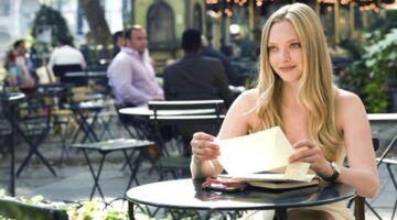 Vrouw zit aan een tafeltje met een brief.