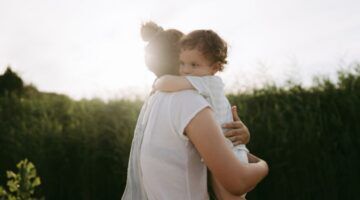 Kind knuffelt een ouder.