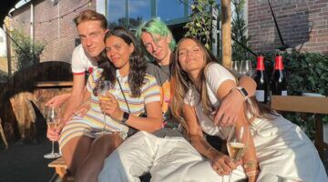 Vier vrienden zitten samen op een terras.