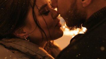 Twee mensen geven elkaar een kus tijdens oudejaarsavond.