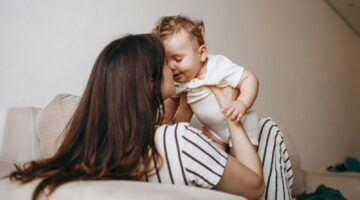 Een vrouw tilt haar kind op.