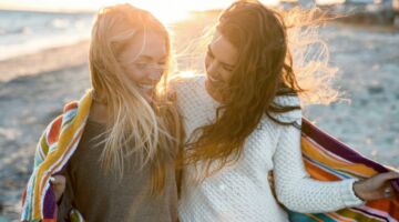 Twee vriendinnen op het strand.