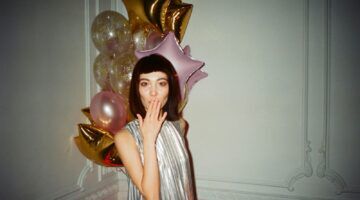 Vrouw met ballonnen en een glitter jurk.