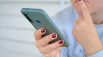 Vrouw kijkt twijfelend naar telefoon