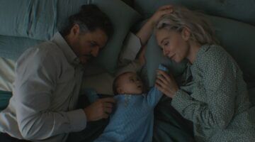 Ouders met een pasgeboren baby op bed.