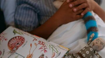 Een kind wordt voorgelezen in bed.