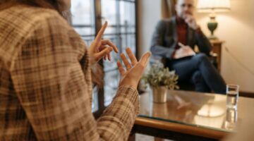 Een vrouw legt iets uit aan haar therapeut.