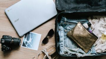 Koffer ligt open met spullen er naast en in.