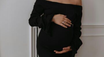 Zwangere vrouw met handen op haar buik.