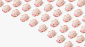 Rijen met kleine roze spaarvarkentjes.