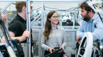 Vrouwelijke ingenieur met mannelijke ingenieurs aan het werk