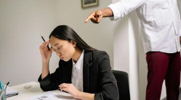 Man wijst corrigerend naar werkende vrouw