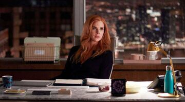 Donna in Suits zit aan haar bureau.