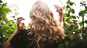 De achterkant van een vrouw met krullende lokken.