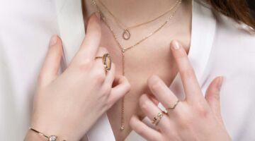 Hals en handen van een vrouw met sieraden.