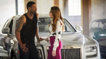 Fallon voor een dure auto met man die indruk op haar probeert te maken uit de serie Dynasty.