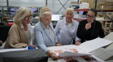 De Grannies van Amsterdam kijken naar een kalender.