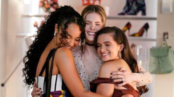 Drie vriendinnen knuffelen elkaar.