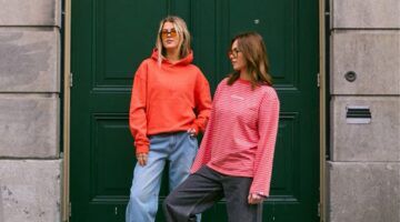 Twee modellen van Sizz the brand voor een groene deur met de nieuwe koninsdagcollectie.