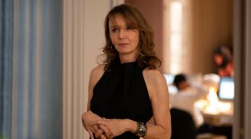 Sylvie staat in een kantoor en kijkt naar de camera.