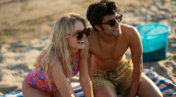 Jongen en meisje lachend op het strand.