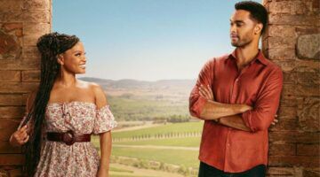 Hoofdpersonages uit You, Me & Tuscany kijken lachend naar elkaar voor een Toscaans landschap.