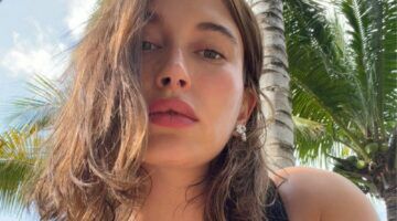 Hailey Bieber kijkt naar de camera en maakt een selfie.