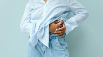 Vrouw met hand op haar buik last van bloating.