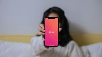 Vrouw houdt Tinder-scherm omhoog.