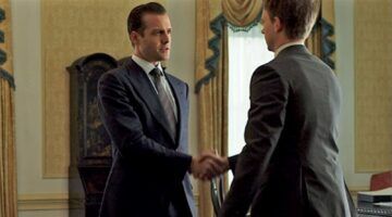Personages uit Suits geven elkaar een hand.
