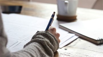 Vrouw schrijft in een schrift.